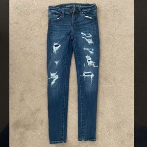 american eagle low rise dark wash ripped but covered hole jeans